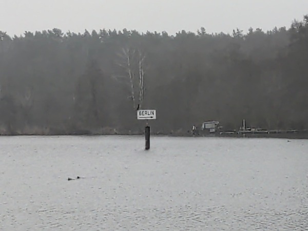 Sign in the water pointing towards Berlin